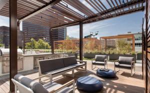 a patio with a bench and chairs and a grill at Luxury Apt Near Kendall Square in Cambridge