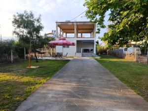 a house with a pathway leading into a yard at 3B House in Nea Vrasna