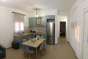 a kitchen with a table and a stainless steel refrigerator at 3B House in Nea Vrasna