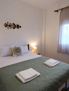 une chambre avec un lit avec deux serviettes dessus dans l'établissement 3B House, à Nea Vrasna 21 autres photos