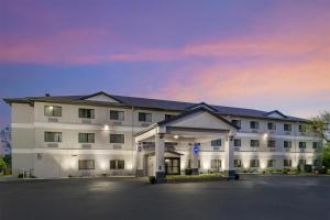 a large white building with a parking lot at Best Western Port Huron Blue Water Bridge in Port Huron