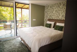 a bedroom with a large bed and a balcony at Una Meryland Rooms & Bungalow in Kulen Vakuf +39 photos