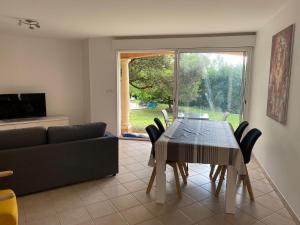 un soggiorno con tavolo da pranzo e divano di Dépendance paisible a Ventenac-Cabardès