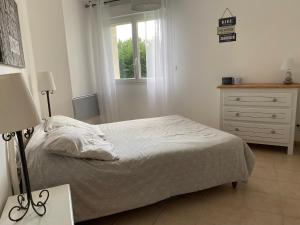 una camera da letto con un letto, un comò e una finestra di Dépendance paisible a Ventenac-Cabardès