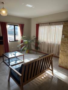 a living room with a bench and a glass table at Casa Las Victorias in San Carlos de Bariloche