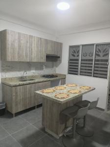 a kitchen with a table with a pizza on it at Casa para vacaciones Neiva Rivera Huila in Rivera