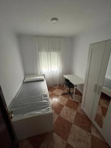 a small room with a bed and a desk at Balneario Cachucha in Puerto Real