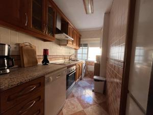 a kitchen with wooden cabinets and a stove top oven at Balneario Cachucha in Puerto Real