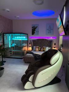 a bedroom with a bed and a chair with purple lights at Aura Apartment und Spa Herne in Herne