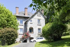 a white car parked in front of a house at Gîte de France Gîte les pierres bleues 2 épis - Gîte de France 2 personnes MAE-4011 in Uzerche