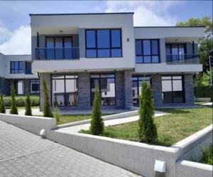 a house with blue windows and a driveway at Вила Соната in Ahtopol