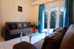 a living room with a couch and a glass table at Garden Apartment in Rethymno