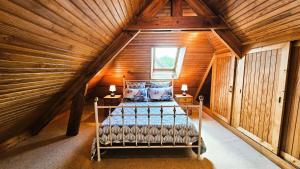 a bedroom with a bed in a wooden attic at Gîte de France Les jeunes années 3 épis - Gîte de France 6 personnes MAE-3553 in Turenne