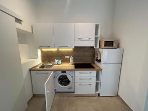 a small kitchen with a refrigerator and a washing machine at Appartamento Monolocale B a Verona in Verona