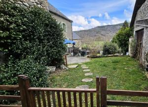 a wooden bench in a yard next to a building at Gîte de France Les saulières pour 2 2 épis - Gîte de France 2 personnes MAE-1333 in Monceaux-sur-Dordogne