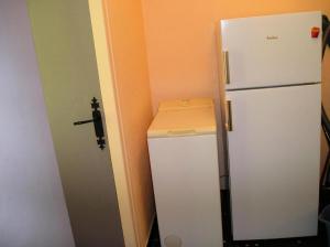 a white refrigerator in a small room with a door at Gîte de France Les saulières pour 2 2 épis - Gîte de France 2 personnes MAE-1333 in Monceaux-sur-Dordogne