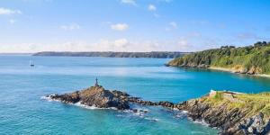 een vuurtoren op een klein eiland in de oceaan bij Maison familiale proche mer - Etables-sur-Mer in Binic +18 foto's