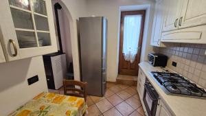 a kitchen with a stainless steel refrigerator and a table at Casa vacanza Auronzo in Auronzo di Cadore