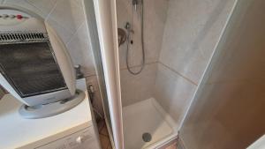 a small bathroom with a shower and a television at Casa vacanza Auronzo in Auronzo di Cadore +1 photo