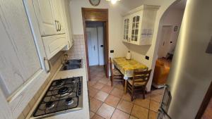 a kitchen with a table and a stove top oven at Casa vacanza Auronzo in Auronzo di Cadore