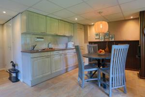 a kitchen with a table and chairs in a kitchen at 't Loekshoes in Tilligte