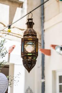 an old fashioned lantern hanging from a string at La Cour Secrète - Riad & Balnéo privée in Carpentras