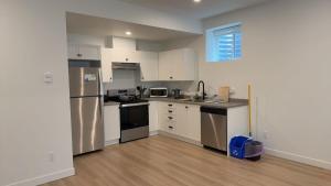 a kitchen with white cabinets and stainless steel appliances at Basement suite -Langley Willoughby in Langley