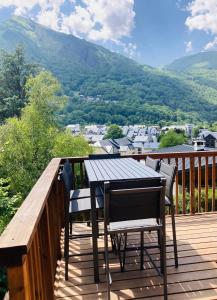 - une table et des chaises sur une terrasse avec vue dans l'établissement Chalet moderne tout confort à st lary village, à Saint-Lary-Soulan