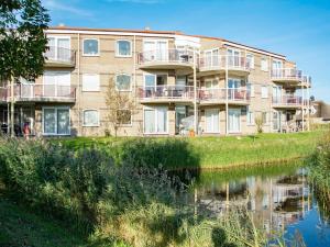 an apartment building next to a body of water at Cozy Dune-View Apartment in De Zandloper