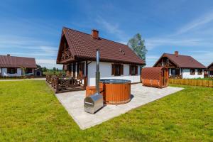 a house with a barbecue grill in the yard at Warmia Prestige in Woryty