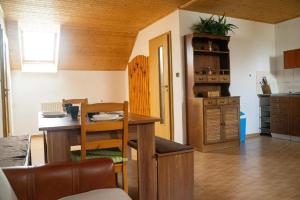 un soggiorno con tavolo e cucina di Apartmány U Petra s pláží a Horní Planá