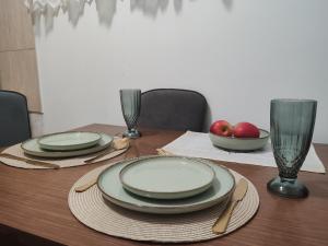 a table with plates and bowls of apples on it at Happy house in Kruševac +5 photos