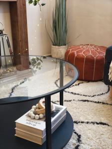 a glass table in a living room with a stack of books at Cosy Flat with IPTV, BB gear Married couples only in Tangier