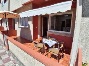 eine Terrasse mit Tisch und Stühlen auf einem Balkon in der Unterkunft Tu Rincón in San Vicente do Mar
