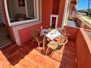 einen Tisch und Stühle auf dem Balkon eines Hauses in der Unterkunft Tu Rincón in San Vicente do Mar