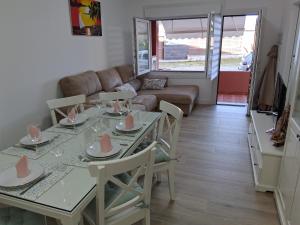 ein Wohnzimmer mit Tisch und Stühlen und einer Couch in der Unterkunft Tu Rincón in San Vicente do Mar + 20 Fotos