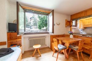 a kitchen and dining room with a table and a window at Accogliente appartamento Erica, Bormio in Bormio
