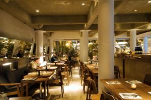 a restaurant with wooden tables and people sitting at them at Habita, Mexico City, a Member of Design Hotels in Mexico City