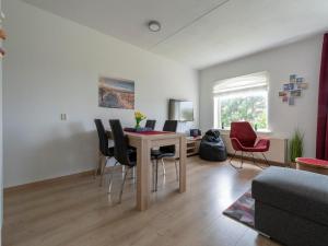 a living room with a dining room table and chairs at Apartment in Julianadorp near the beach in Julianadorp