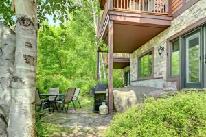 Un patio de una casa con una mesa y sillas. en 124 Algonquin - Ski In Out Tremblant Mountainside Chalet, en Mont-Tremblant