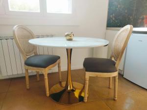 a table with two chairs and a table with a bowl on it at Résidence P&C Fragrance Studio in Neuilly-sur-Marne