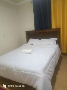 a large white bed with white sheets and pillows at KISERIAN Stay Home Accomodation in Nairobi