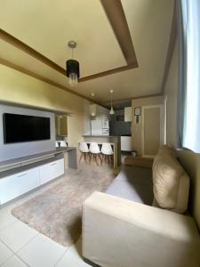 un salon avec un canapé et une télévision à écran plat dans l'établissement Apartamento Mobiliado - COP 30, à Ananindeua