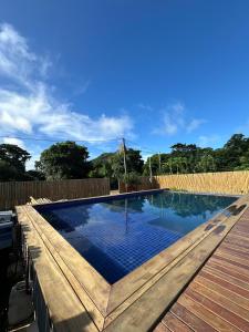 a swimming pool in a backyard with a wooden deck at Pousada Terras Verdes Residence in Fernando de Noronha