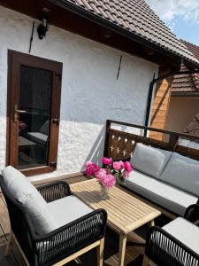a patio with a couch and a table with flowers at Chalupa Daša-tiny house in Trstené +23 photos