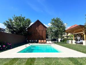 ファガラシュにあるHorace Exclusive Residence Fagarasの納屋付きの庭のスイミングプール