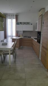 a large kitchen with a table and a table and chairs at La Casetta in Fragagnano