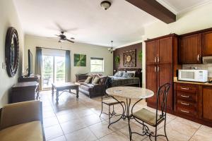 a living room with a table and a kitchen at Garden Studio, Ocean Dream in Cabarete