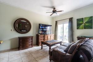 a living room with a couch and a flat screen tv at Garden Studio, Ocean Dream in Cabarete