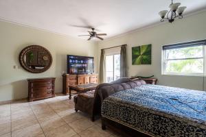 a bedroom with a bed and a mirror and a tv at Garden Studio, Ocean Dream in Cabarete